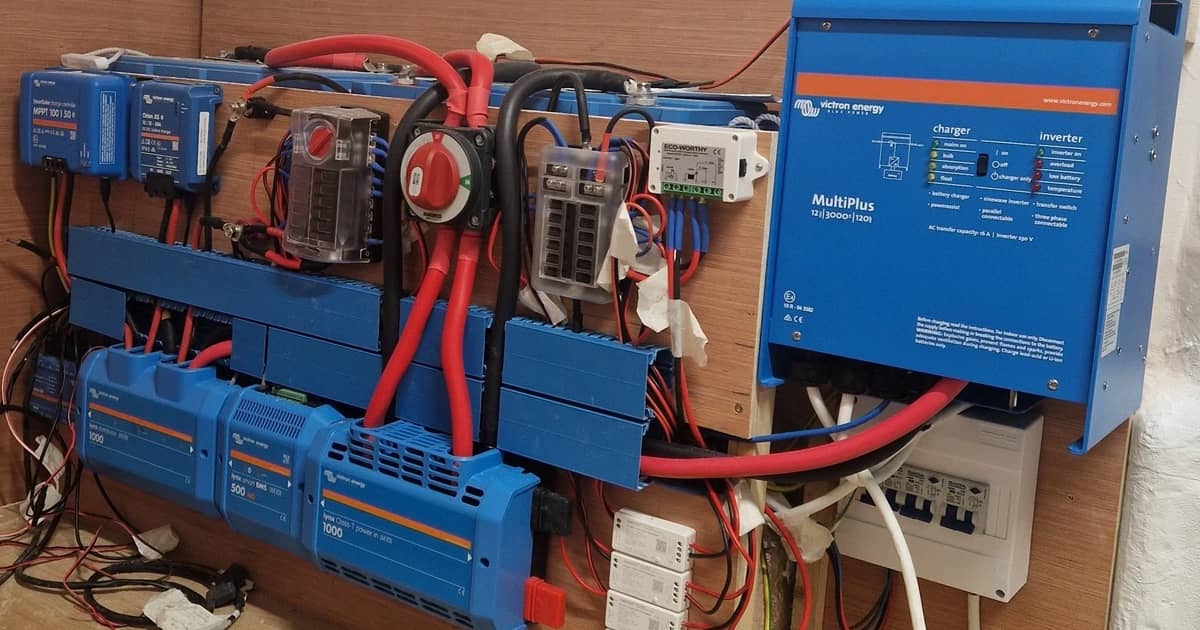 Inverter/caricabatterie Victron, regolatori di carica solare e barre collettrici montati sulla parete di un camper
